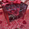 Red roses in a clear gift box with a satin bow