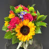 A bold yellow sunflower takes center stage in this cheerful flower arrangement