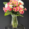 Soft pink alstroemeria and ruffled carnations take center stage in this cheerful