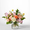 Mixed bouquet of roses and pink flowers in a clear glass vase
