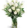 White roses in a clear glass vase with baby's breath