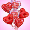 Cluster of heart-shaped red and pink balloons with love messages