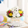 Colorful flower arrangement in a polka-dot box with a teddy bear centerpiece