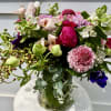 Scabiosa, garden roses, tweedia, hellebores, anemone with eucalyptus in a clear glass