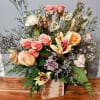 The Arrangment has beautiful Autumn Lillies and Soft Peach Roses mixed with