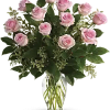 Arrangement of light pink roses in a clear glass vase with visible stems