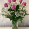 6 beautiful lavender roses arranged in a vase with baby's breath and