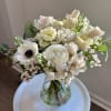 A fresh, airy arrangement featuring layered white blooms, soft texture, and natural