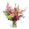 Mixed bouquet of pink roses, calla lily, and purple flowers in a glass vase