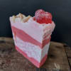Pink layered soap bar topped with a red heart-shaped candy
