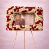 Tall standing rectangular wreath of red and white roses framing a religious icon on an easel.