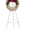 Standing funeral wreath with red and white flowers on a metal easel