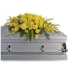 Yellow floral spray on a silver casket