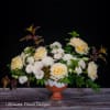 Cream and pale yellow roses arranged in a terracotta pedestal vase