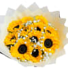 Hand-tied bouquet of bright yellow sunflowers with white filler flowers in cream paper wrap