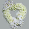 Heart-shaped wreath of white orchids and chrysanthemums on a gray background
