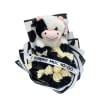 Black and white carnation bouquet with plush cow toy and ribbon reading 'Te quiero mucho-oo'.