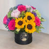 Bright mixed bouquet in a black round box with sunflowers and pink roses