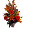 Tall bouquet of orange lilies, gerbera daisies, and pink roses in a glass vase