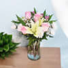 Pink roses and white lilies arranged in a clear glass vase