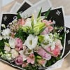 Bouquet of pink and white flowers wrapped in black paper
