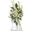 Tall white and pale yellow funeral spray on a stand