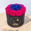 Round box of pink and blue roses on a table