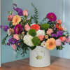 Colorful mixed flower arrangement in a white hat box