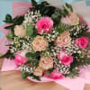 Bouquet of pink and blush roses with baby's breath in pink wrapping