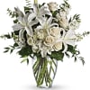 White lilies and roses in a clear glass vase