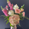 Arrangement of pink and white flowers with hydrangea and roses in a metallic rose-gold vase