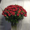 Large arrangement of red roses in a tall clear glass vase