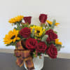 Arrangement of red roses and yellow sunflowers in a white container with a plaid bow.