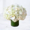 White floral arrangement in a green glass vase