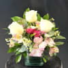 Soft pink spray roses and alstroemeria cradle three tall white roses to