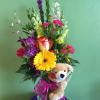 Mixed bouquet in a glass vase with a plush teddy bear and pink ribbon