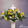 Yellow roses and white daisies in a pedestal vase with a white cross centerpiece