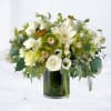 White and green mixed flower arrangement with orchids and roses in a clear glass cylinder vase