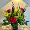 Mixed bouquet with pink roses, yellow daisies, and lilies in a vase