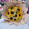 Bouquet of sunflowers, yellow roses, and small white daisies wrapped in tan paper