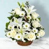 White lilies, roses, and daisies arranged in a wicker basket