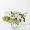 White lily and mixed white flowers in a clear glass vase