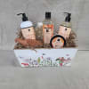 Bath gift set with orange ginger products in a floral-printed white wooden box filled with paper shred.