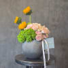 A radiant arrangement of blush roses and fresh green hydrangea, accented with