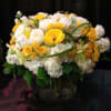 Yellow and white mixed flower arrangement in a glass vase