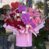Large pink hat box of red and pink roses with purple orchids and a red heart pick
