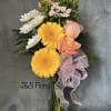 Bouquet of yellow gerbera daisies, pink roses, and white daisies in a glass vase