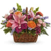 Basket of pink lilies, orange roses, and purple flowers