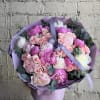 Large round bouquet of pink and white peonies with pale pink roses wrapped in lavender paper and ribbon