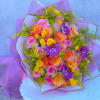 Large bouquet of pink, orange, and yellow roses with purple orchids wrapped in lavender paper.